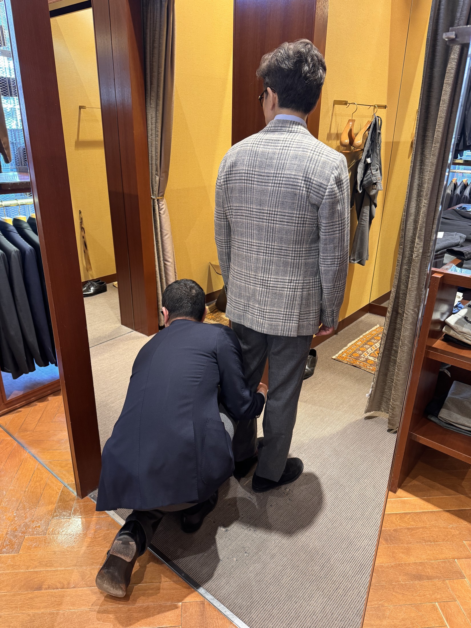 ジャケットとパンツのサイズを細かく確認する試着風景
